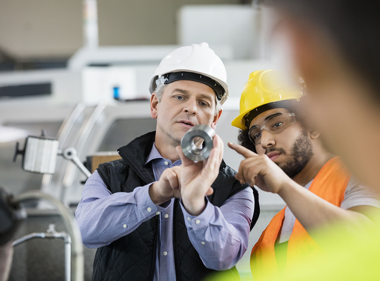 factory workers reviewing a part