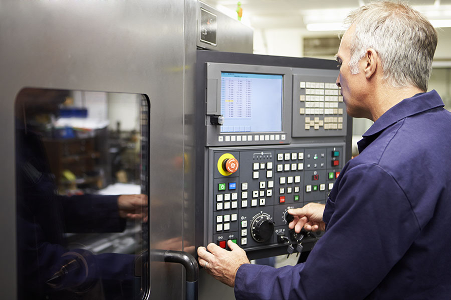 factory working at control panel of machine